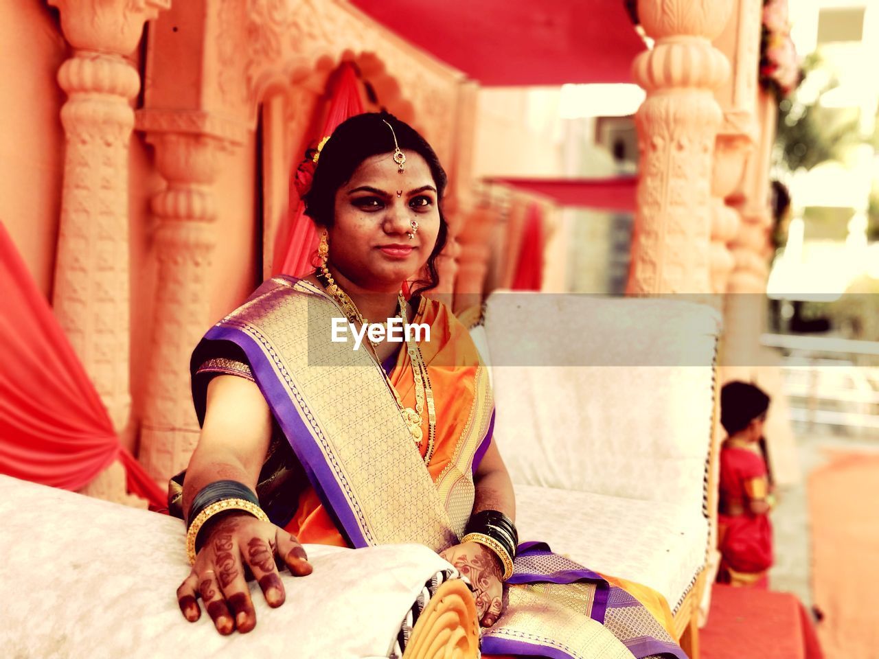 Portrait of woman wearing sari while sitting on sofa during celebration