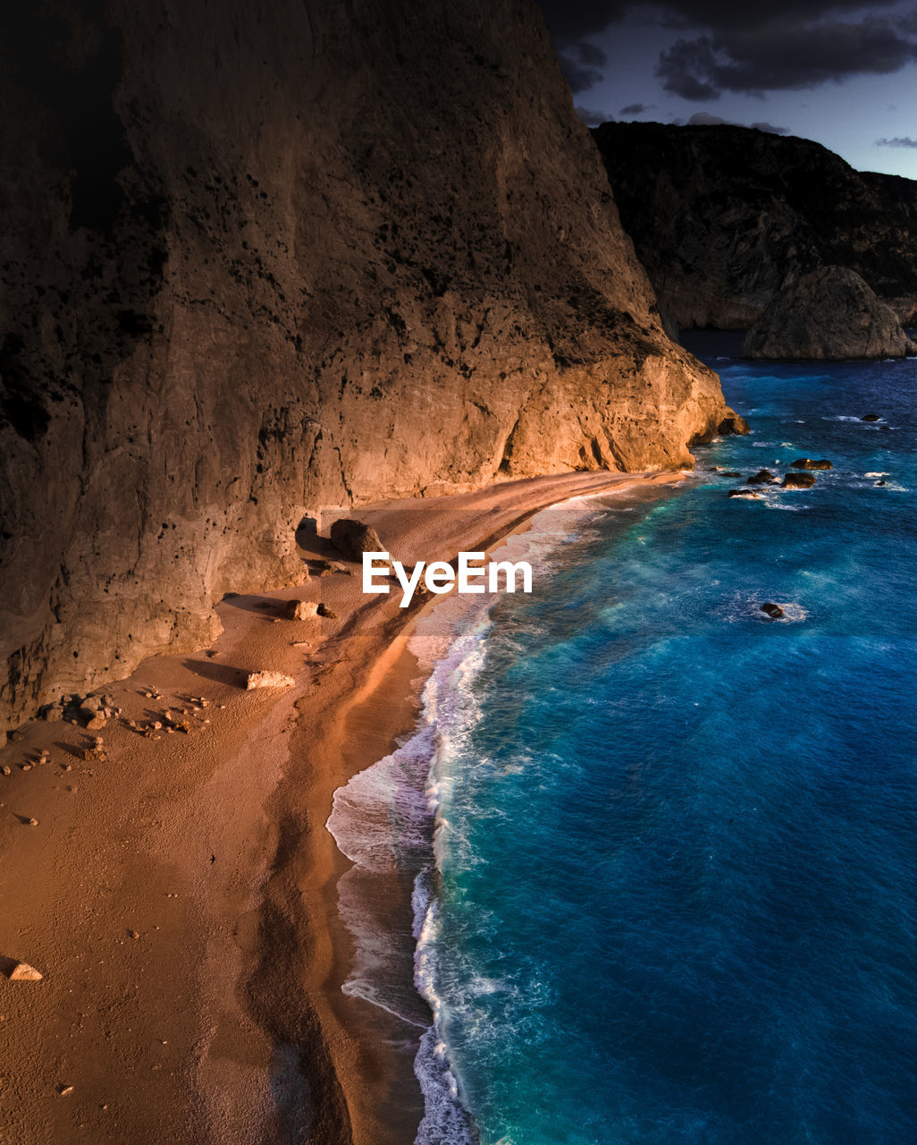 Rock formation on beach against sky