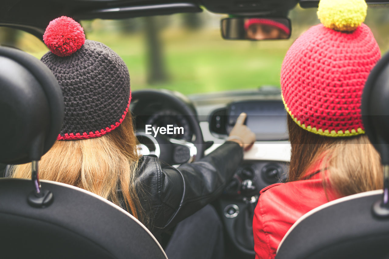 Girls sitting in the car. teen in front of the steering wheel with friend . women enjoying free time