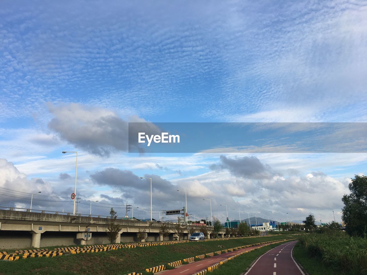 Road by bridge against sky in city