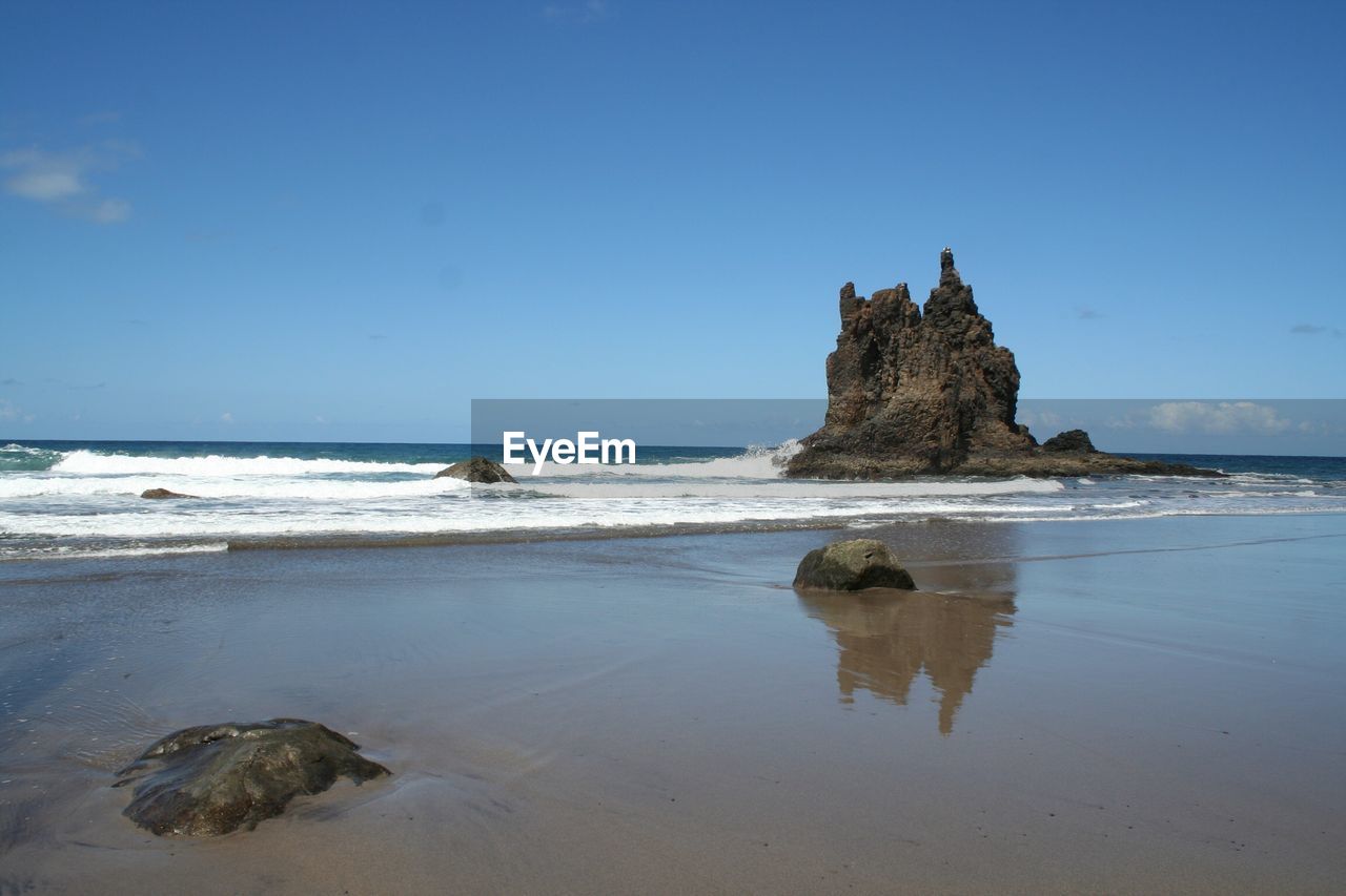 SCENIC VIEW OF ROCKS ON BEACH AGAINST SKY