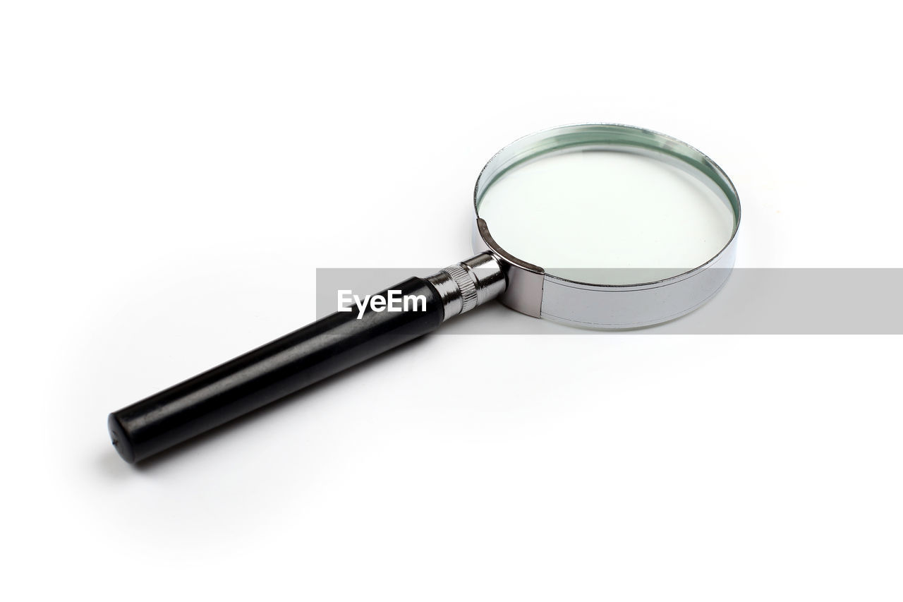 High angle view of magnifying glass over white background