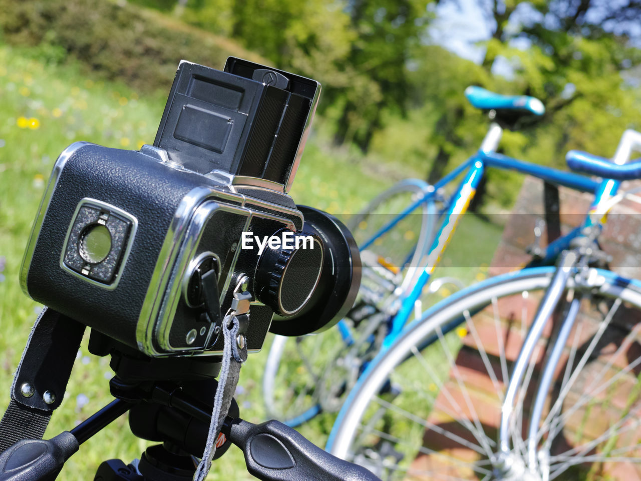 Close-up of camera and bicycle on field