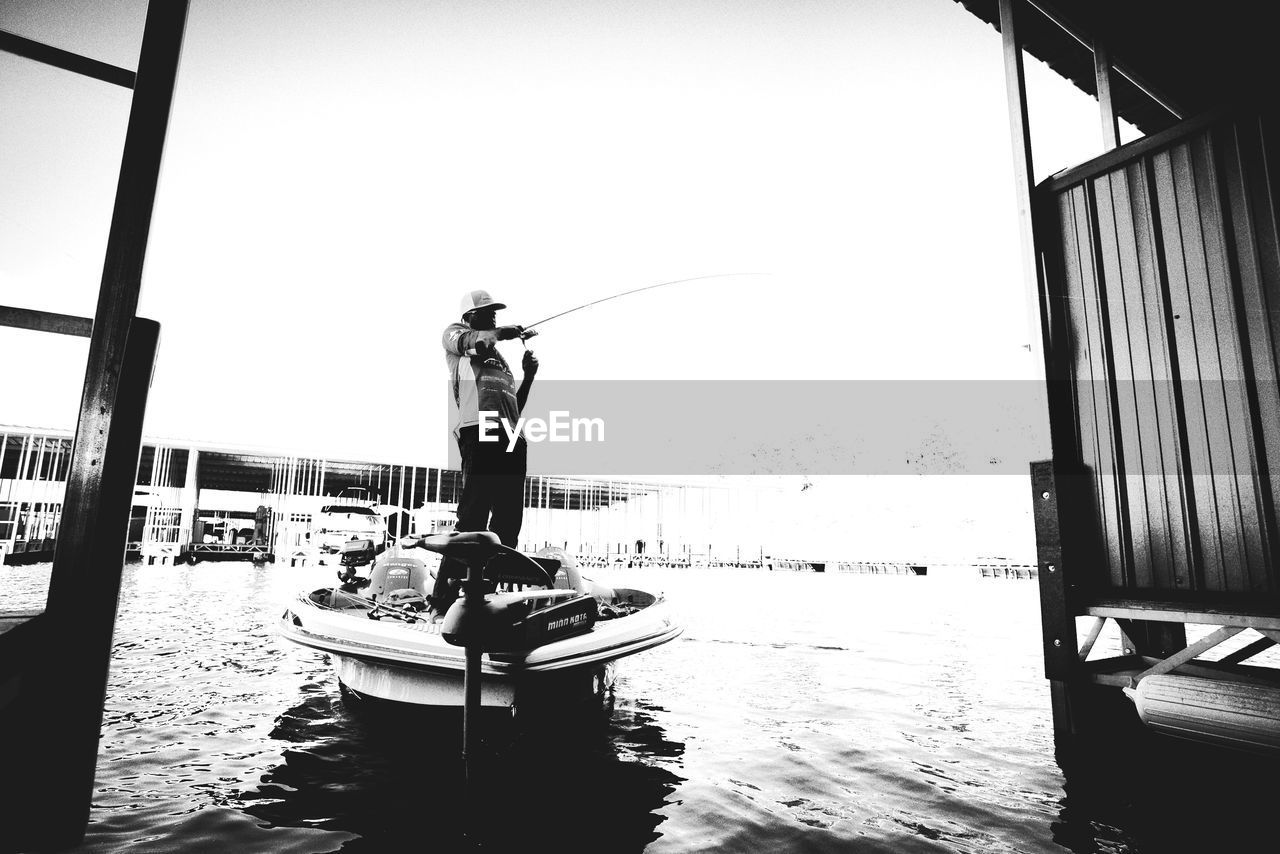 Man fishing while standing in boat