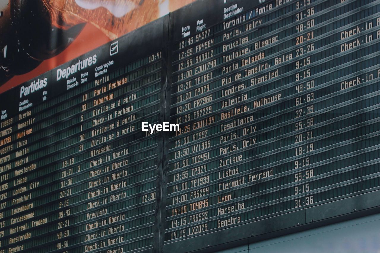 Low angle view of information on arrival departure board at airport