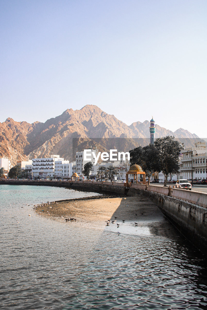 scenic view of river by buildings against clear sky