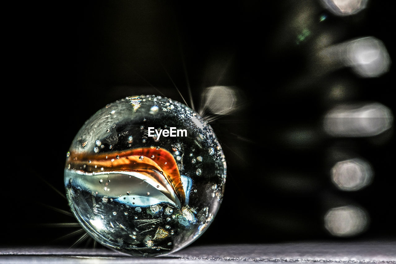 CLOSE-UP OF CRYSTAL BALL IN GLASS