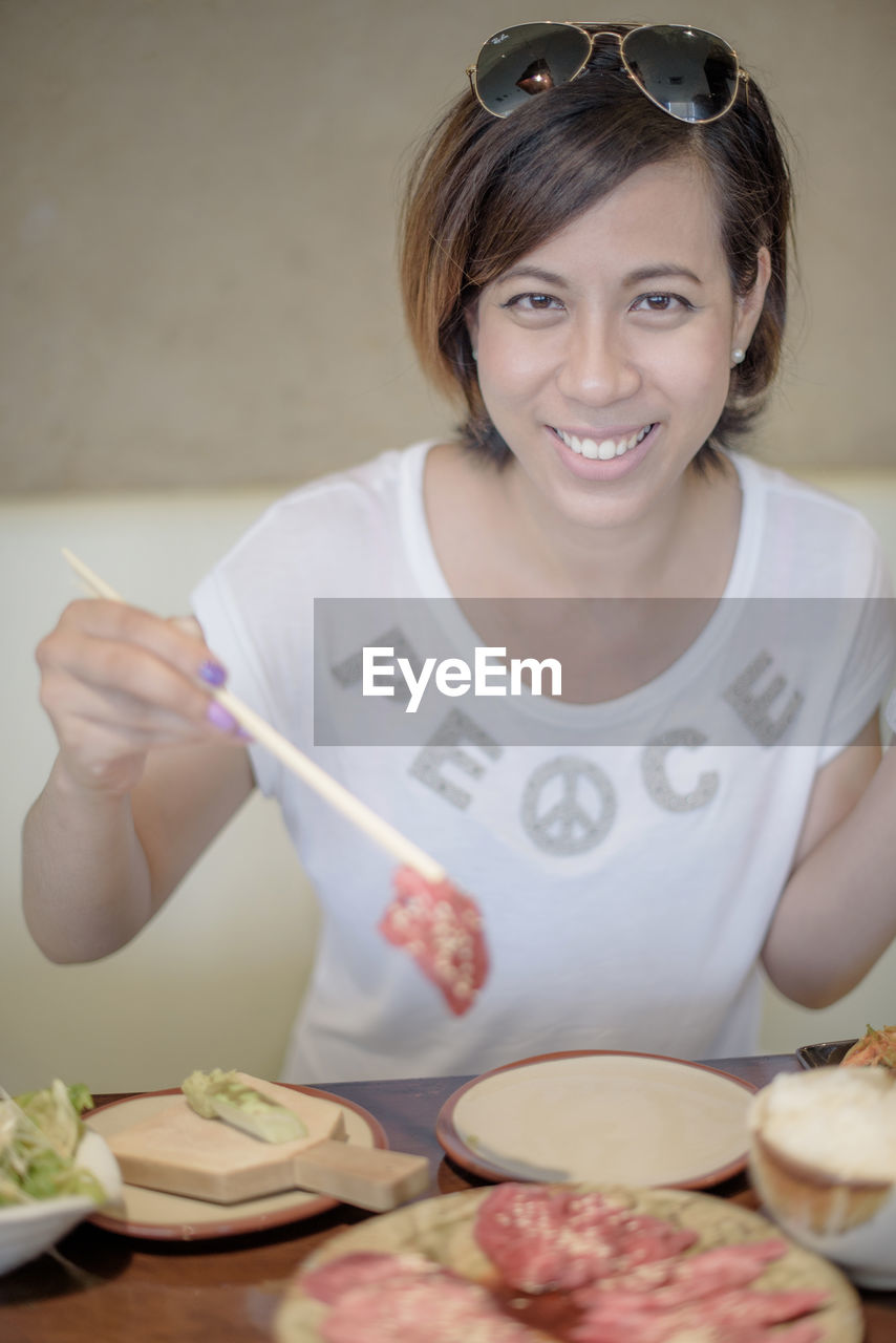 Portrait of young woman having lunch in restaurant