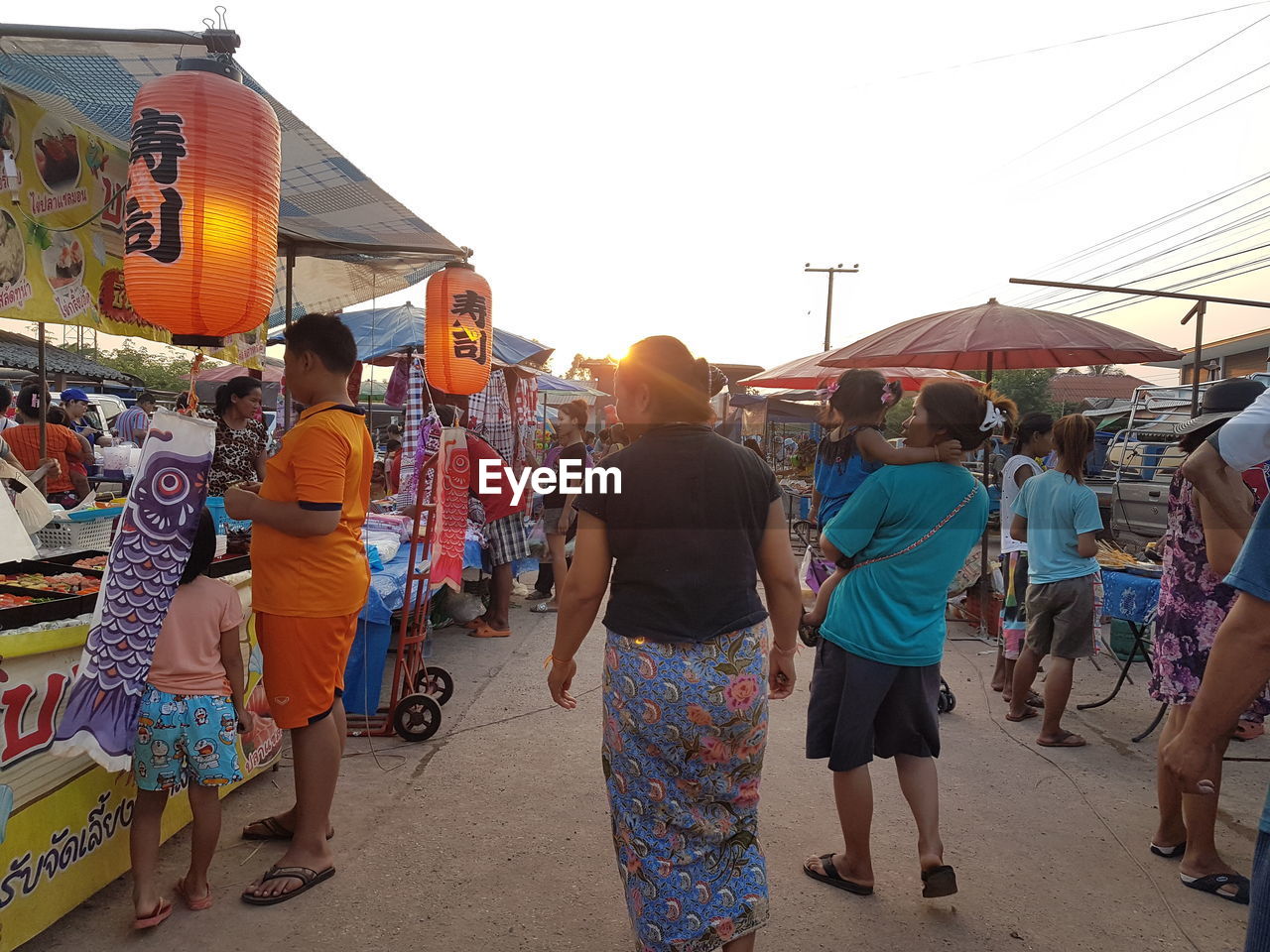 PEOPLE WALKING ON STREET MARKET AGAINST SKY