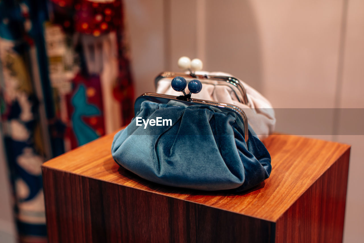 Soft velvet blue and white clutches on a wooden stand. fashion details, women's accessories