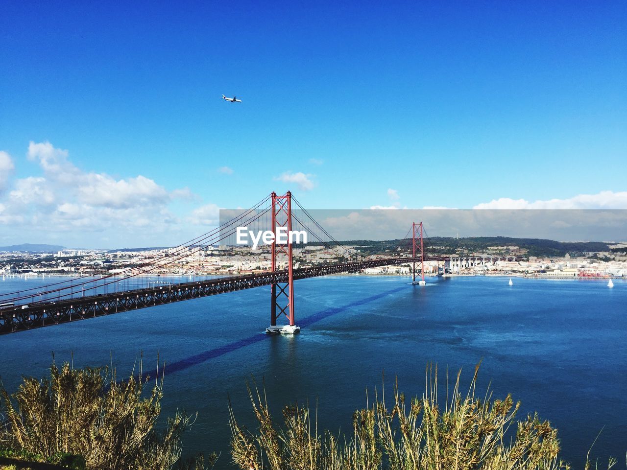 25 de abril bridge over tagus river against sky in city