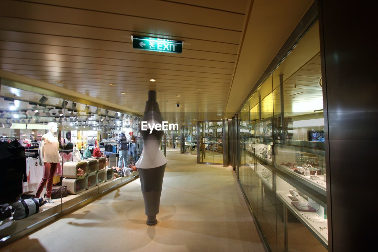 WOMAN WALKING IN ILLUMINATED UNDERGROUND WALKWAY