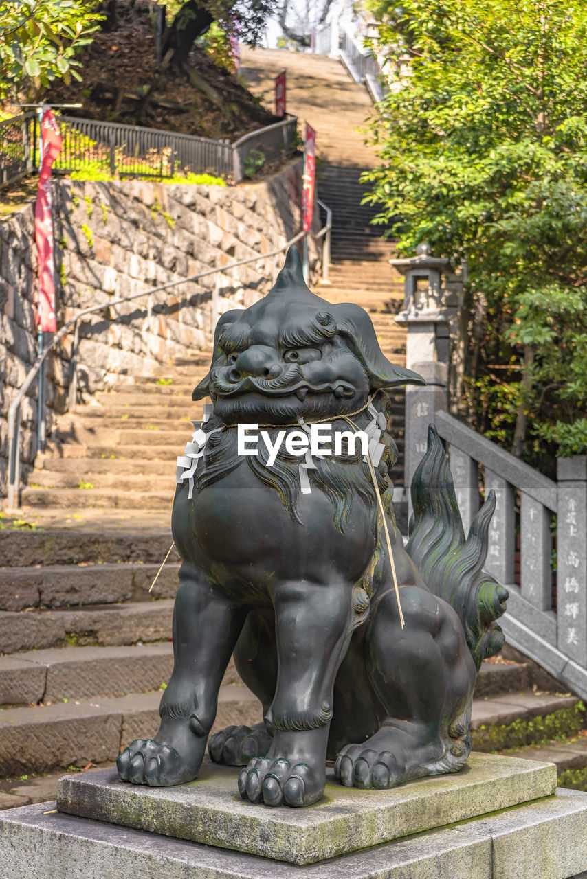 STATUE OF BUDDHA AGAINST TREE