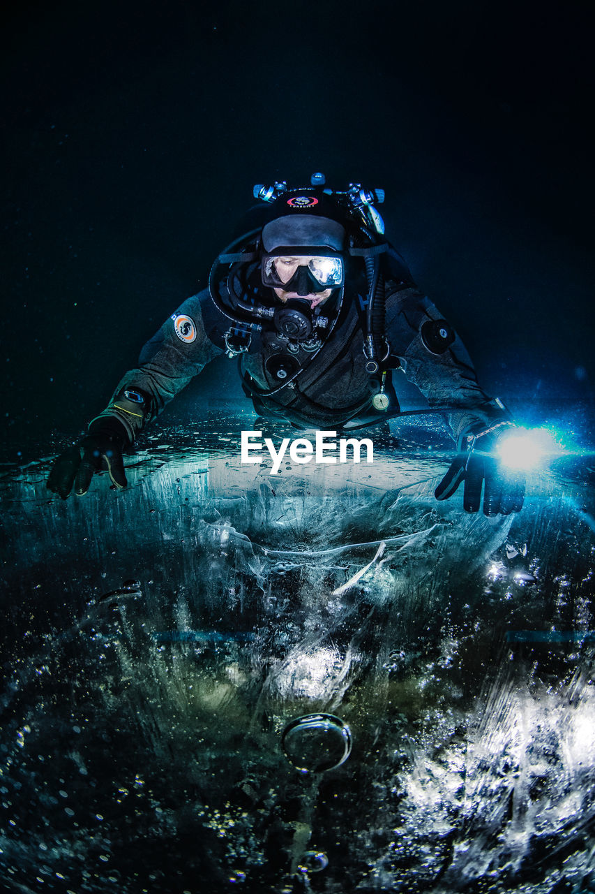 CLOSE-UP OF A MAN WITH WATER IN BACKGROUND