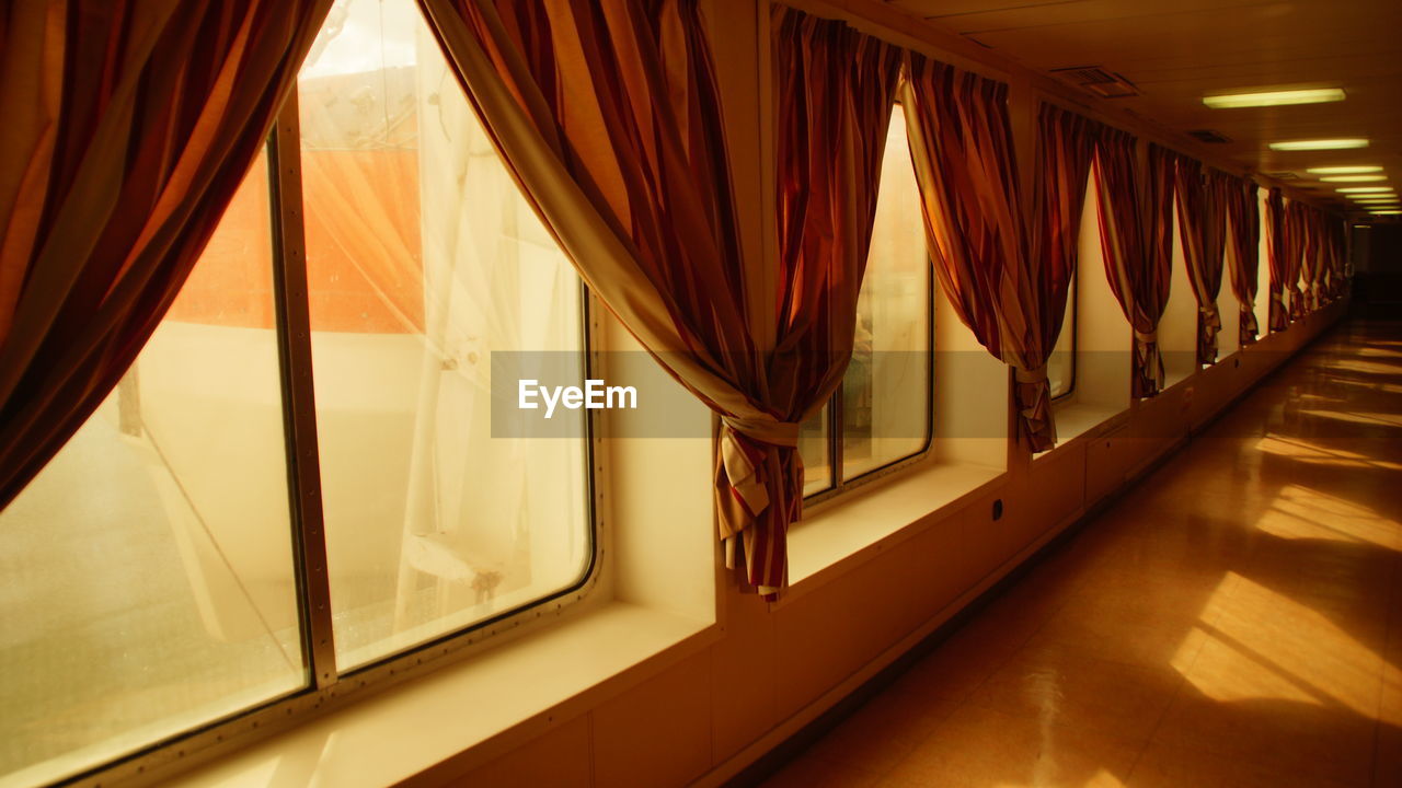 View of curtains on windows at corridor