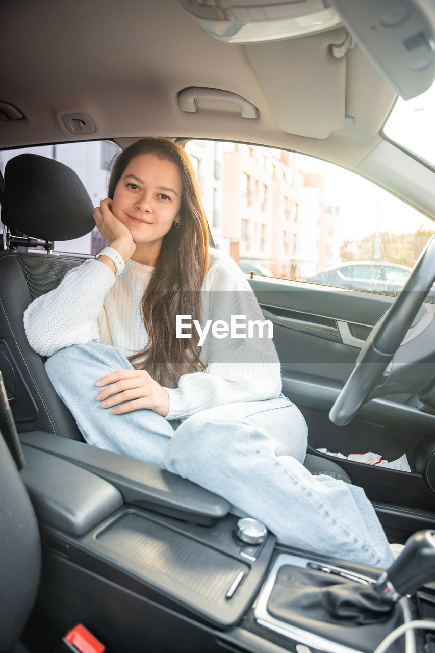 portrait of smiling young woman sitting in car