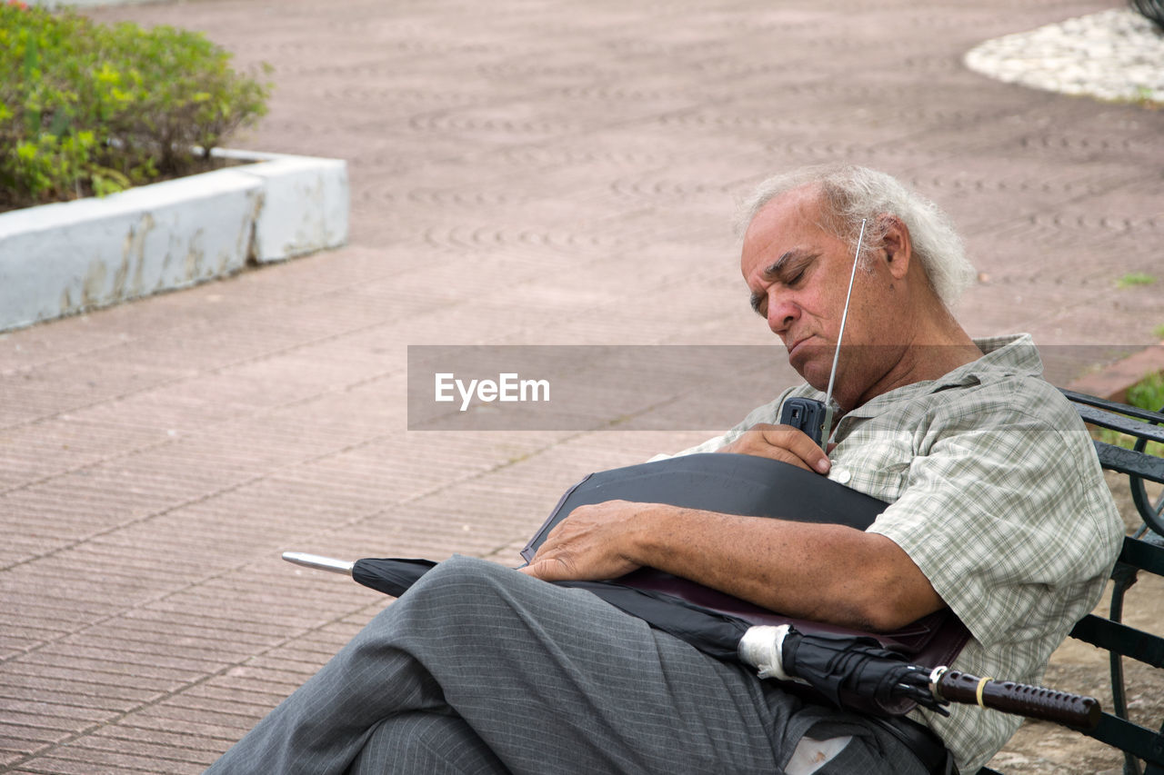 Man listening radio while sleeping on chair