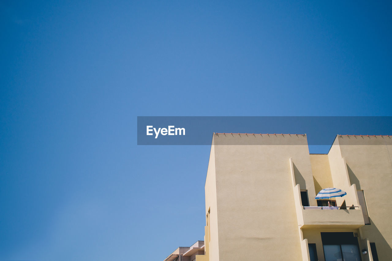 Low angle view of building against clear blue sky