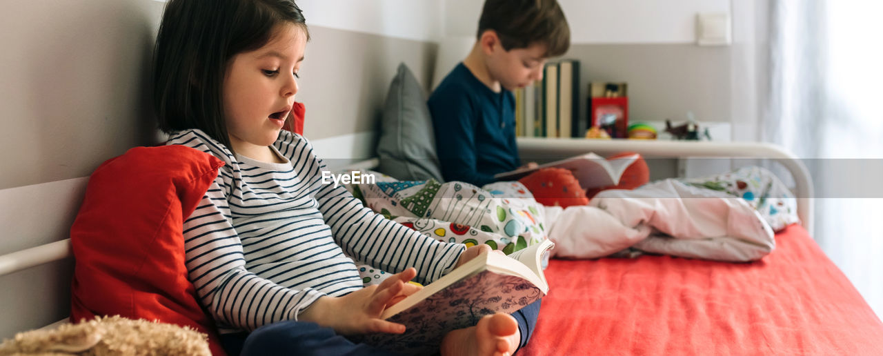 WOMAN SITTING ON BED AT HOME