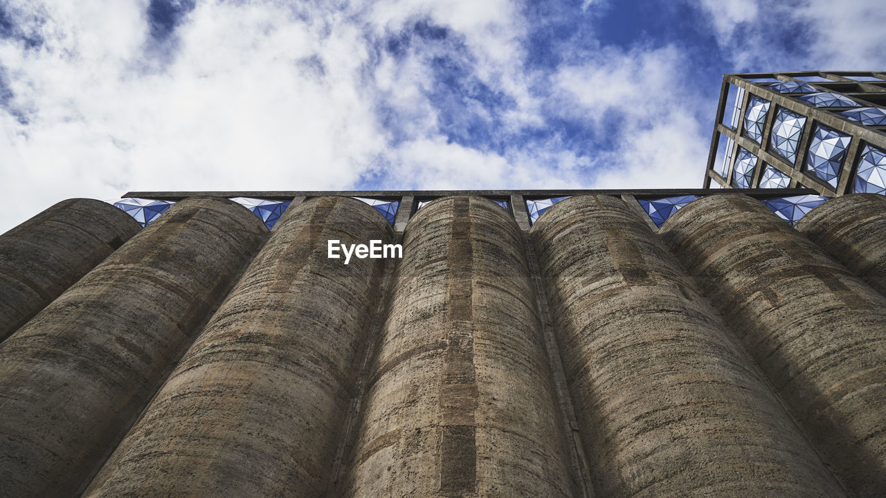 LOW ANGLE VIEW OF INDUSTRIAL BUILDING AGAINST SKY