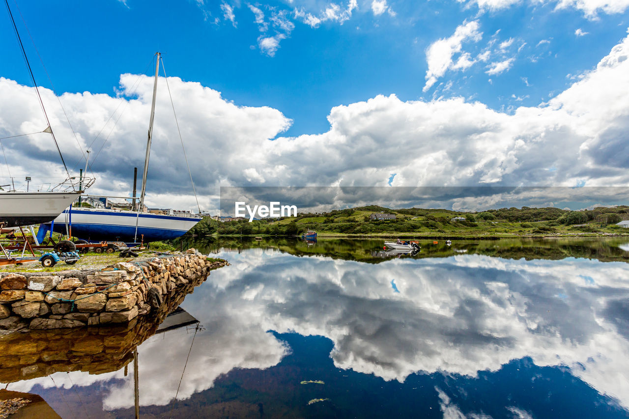 Scenic view of clifden bay at high tide against blue sky, reflection of clouds on water surface