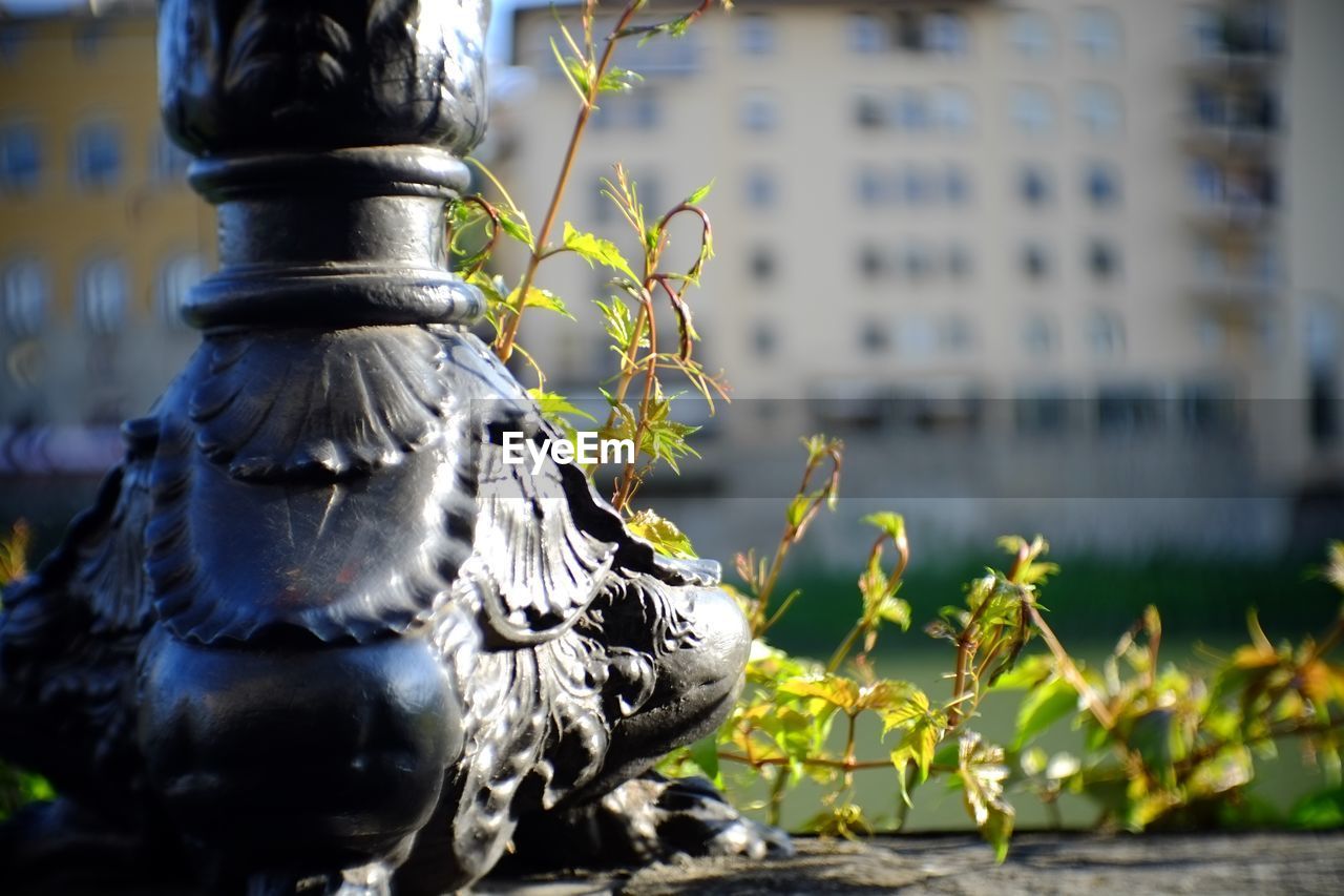 CLOSE-UP OF STATUE WITH FOUNTAIN AGAINST BUILDING