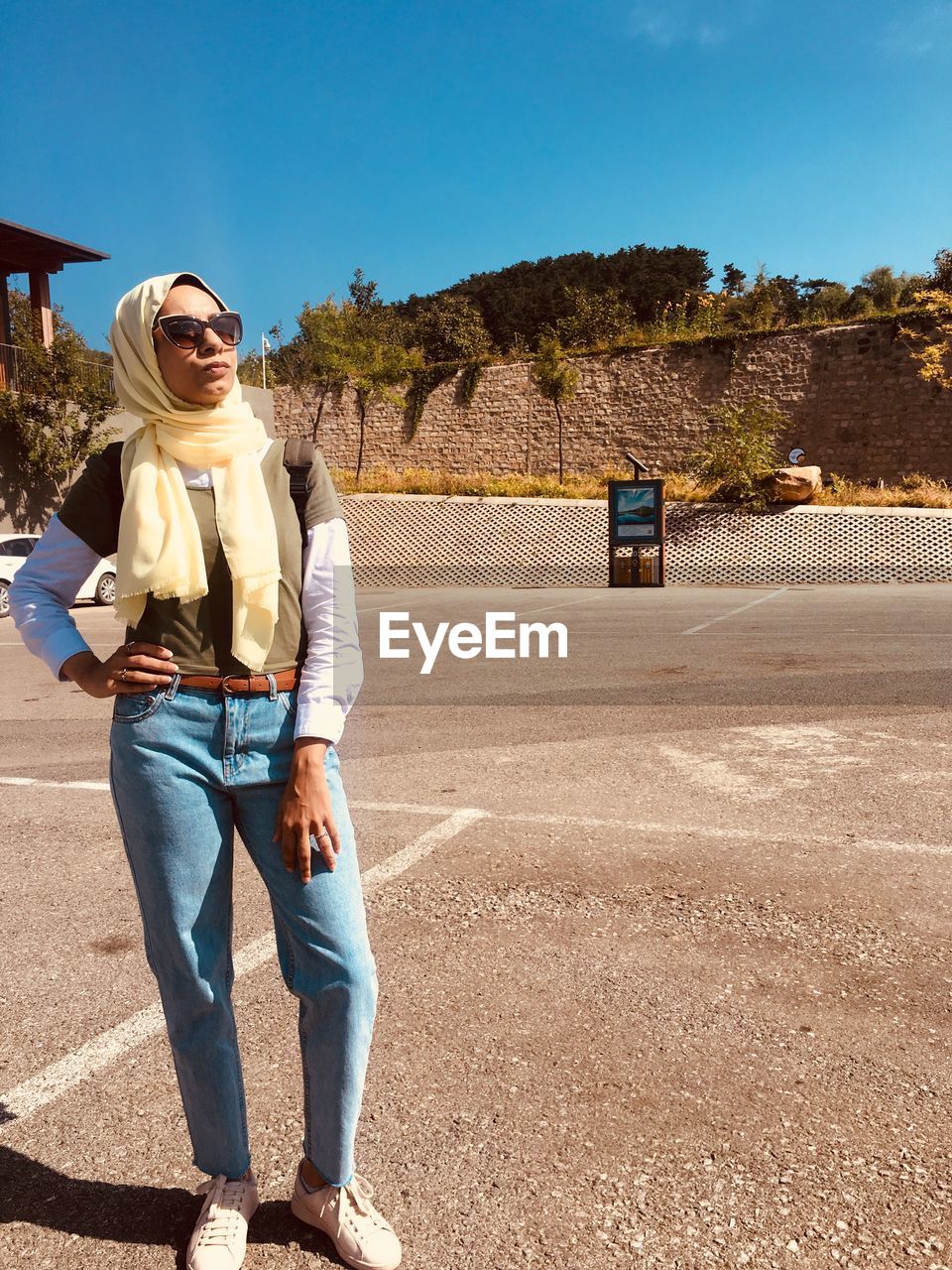 Young woman standing on road against sky