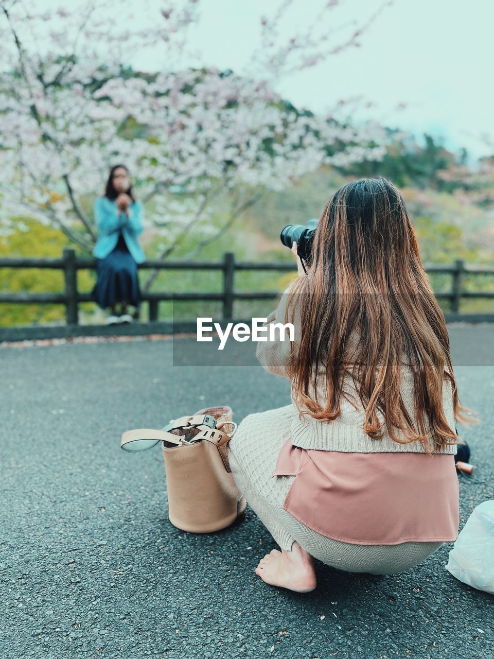 Woman photographing while sitting outdoors