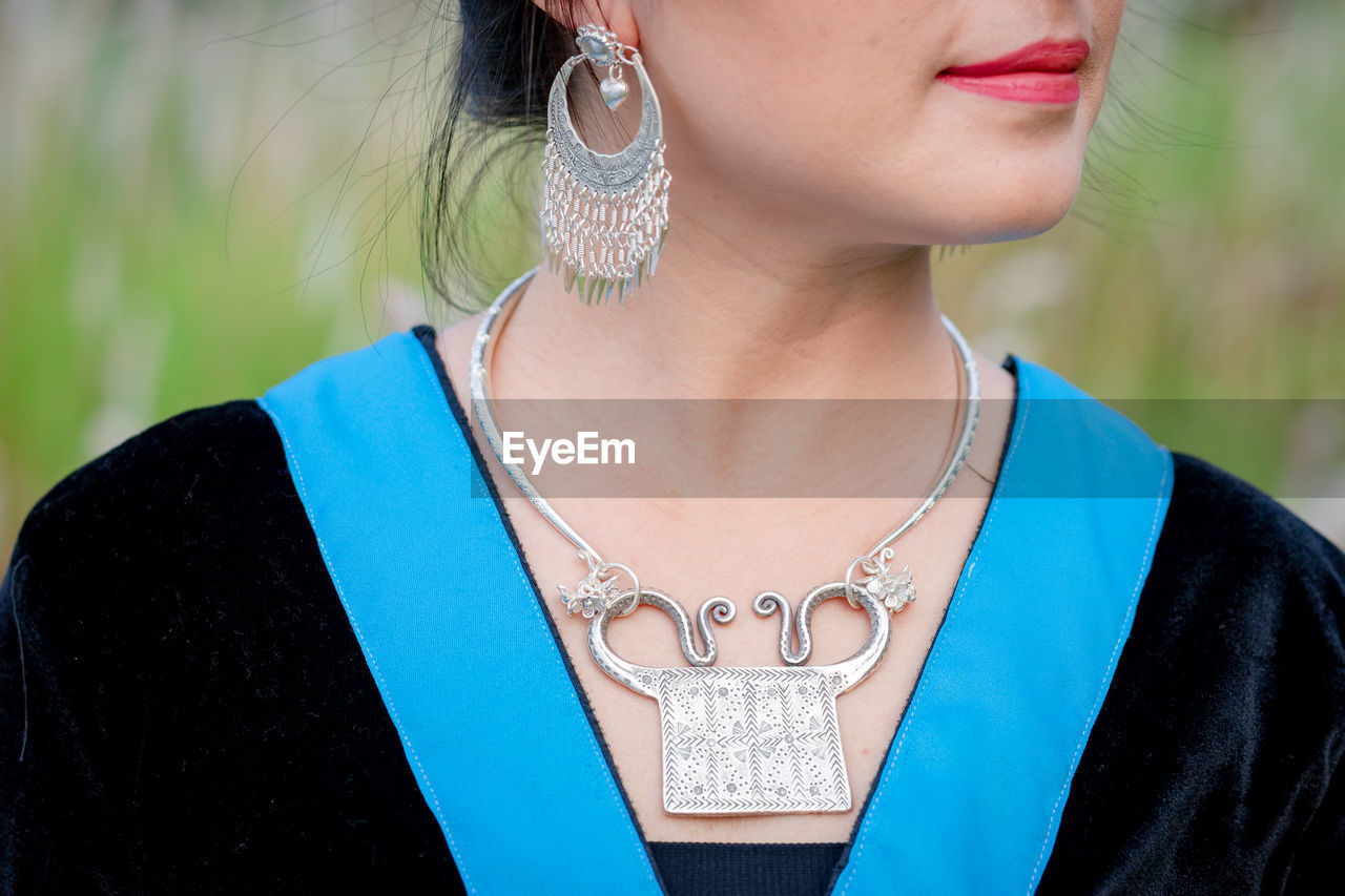 Close up shot of woman with silver choker and silver earrings