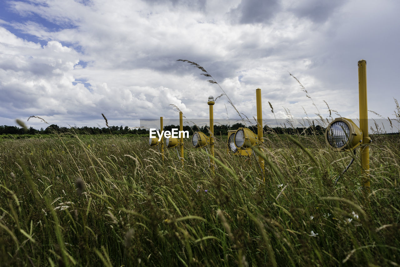 Scenic view of agricultural field and landing stripes against sky