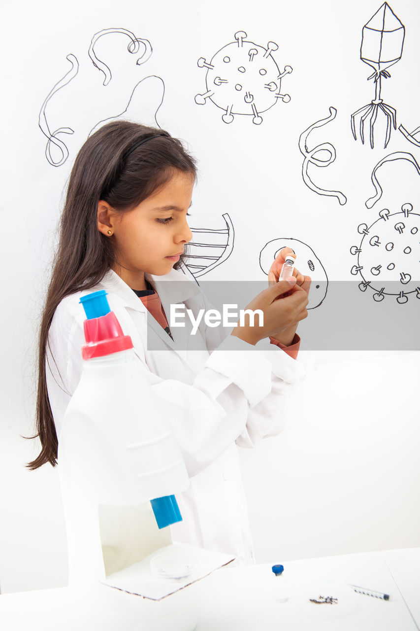 Young girl playing a life sciences professional role. could be biologist, doctor, researcher. 