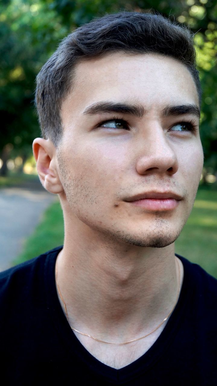 Close-up of thoughtful young man at park