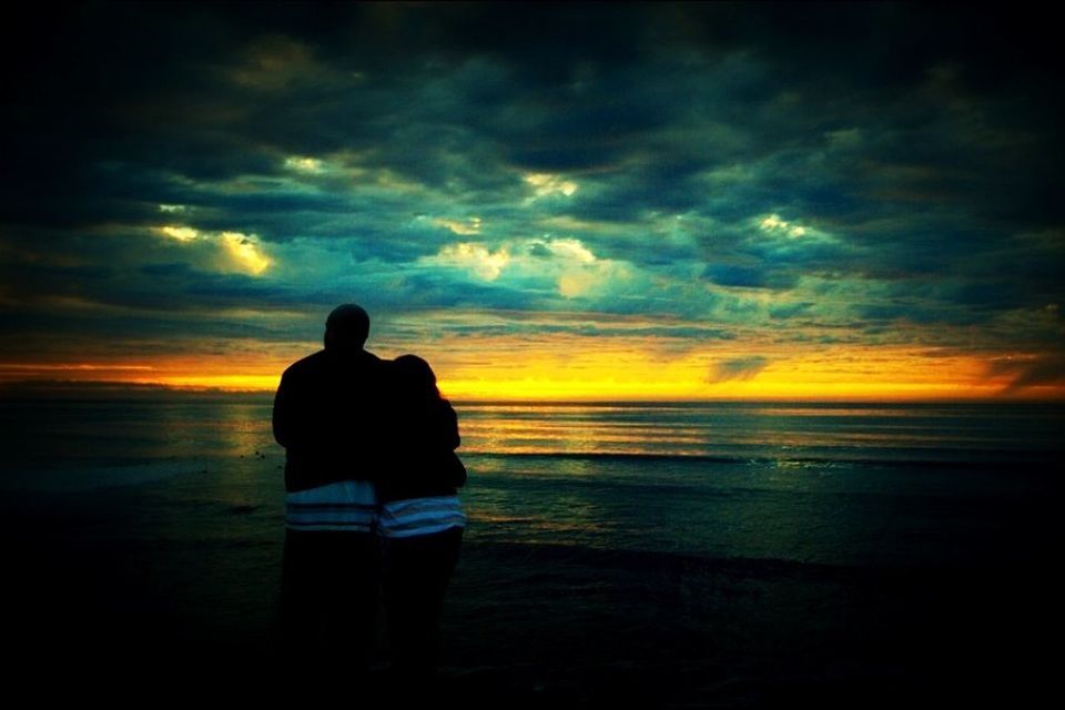 SILHOUETTE OF PEOPLE STANDING ON BEACH