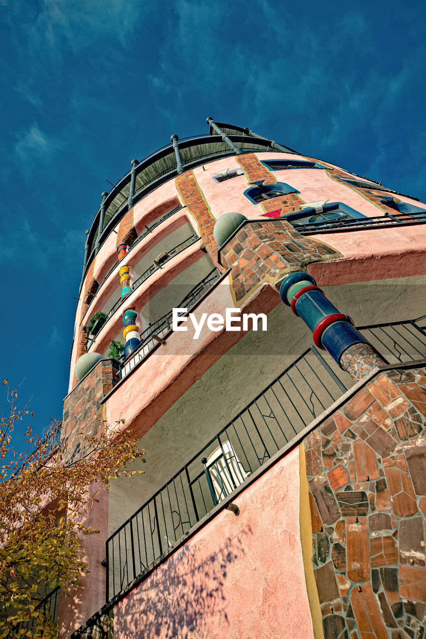 LOW ANGLE VIEW OF ABANDONED BUILDING AGAINST BLUE SKY