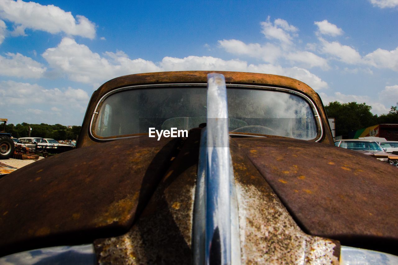 Close-up of vintage car against sky
