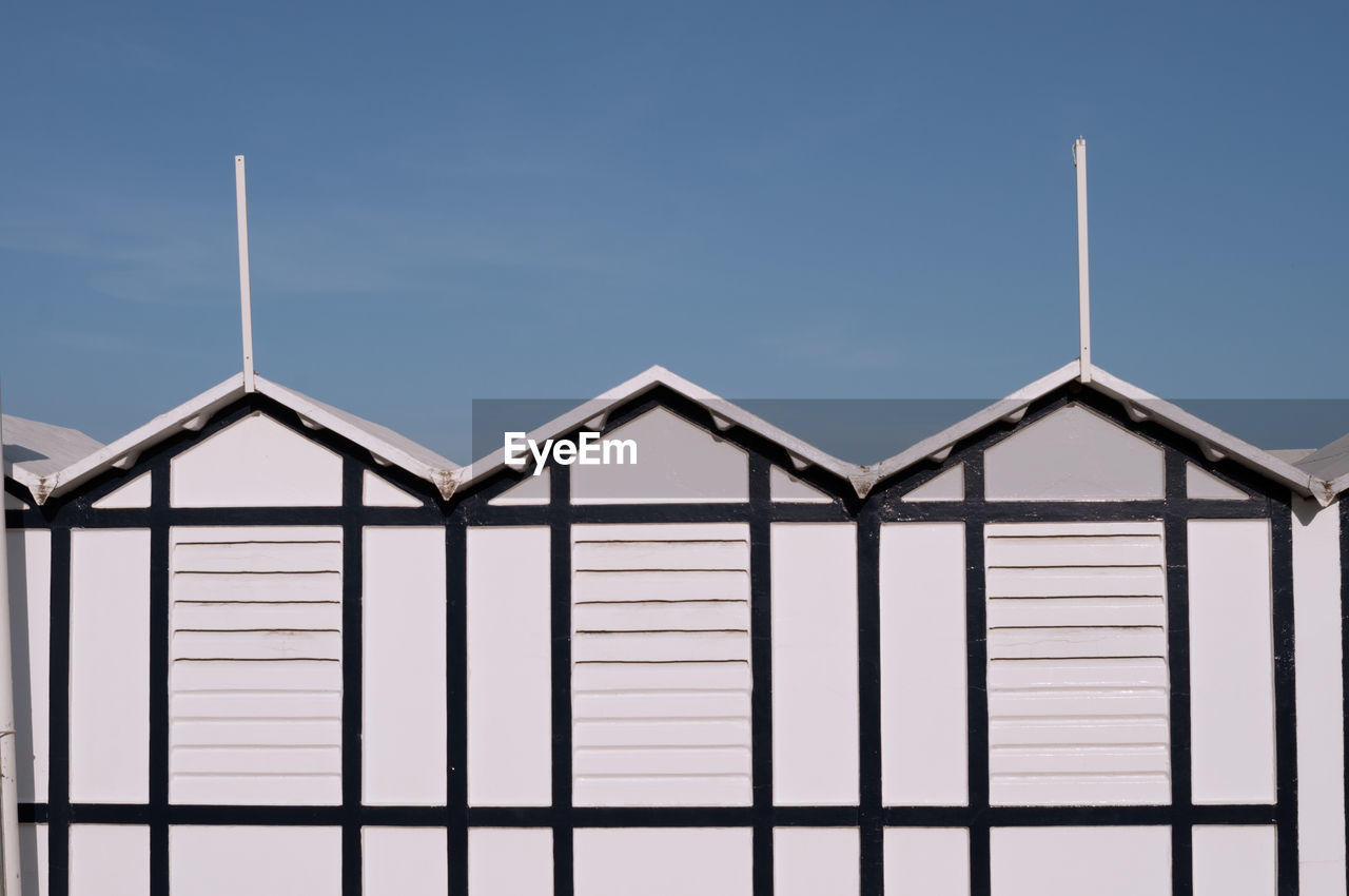 Detail of typical beach huts in italy. white, with a beautiful blue sky in the background