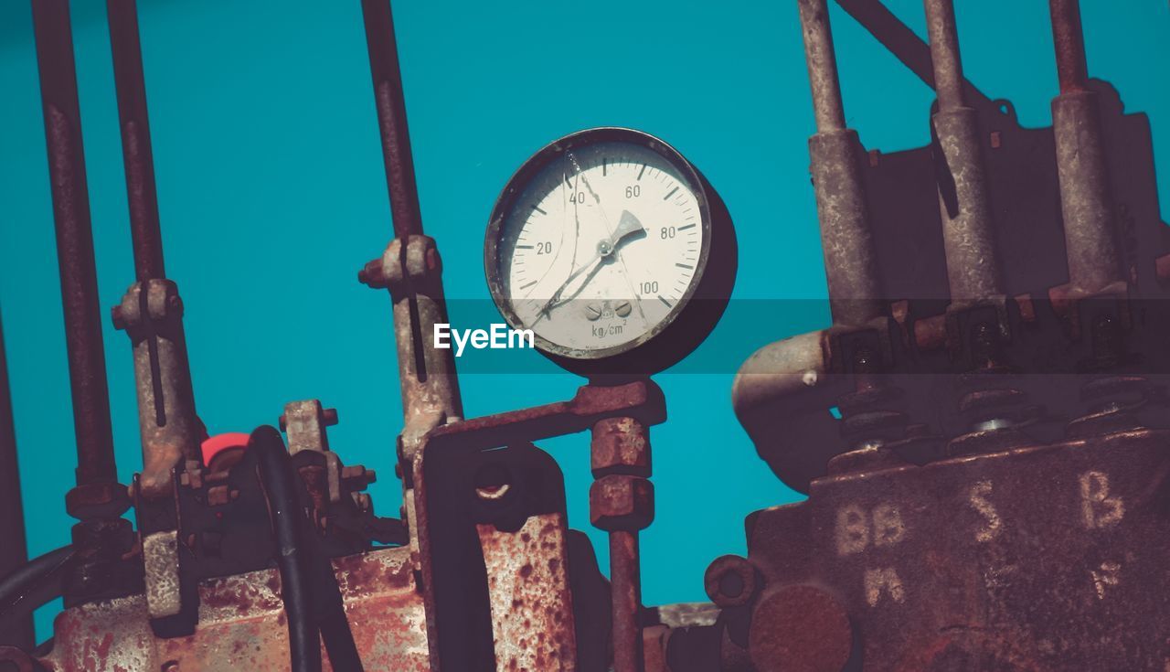 Low angle view of pressure gauge against clear sky