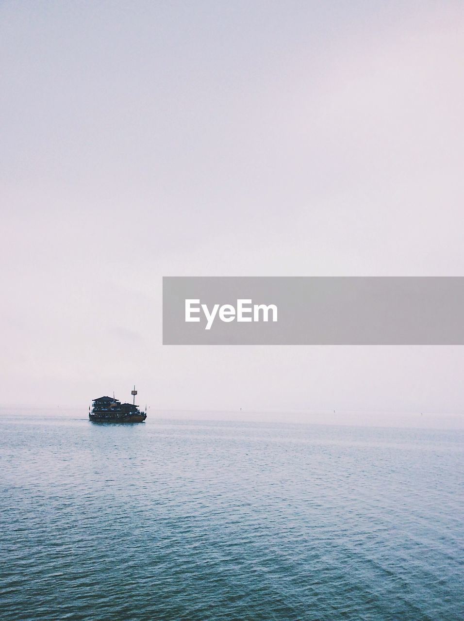 BOAT SAILING IN SEA AGAINST SKY