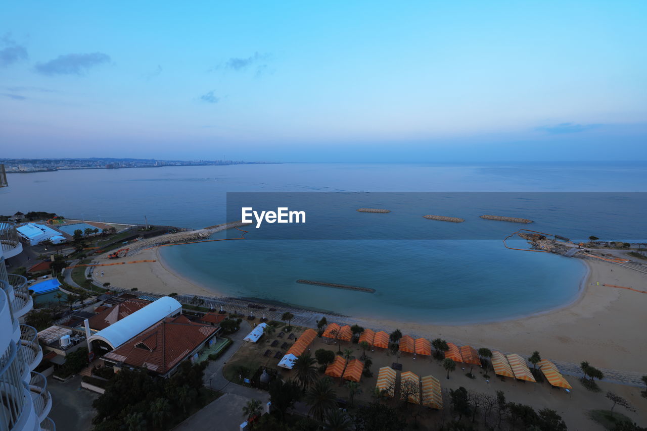 High angle view of buildings by sea against sky