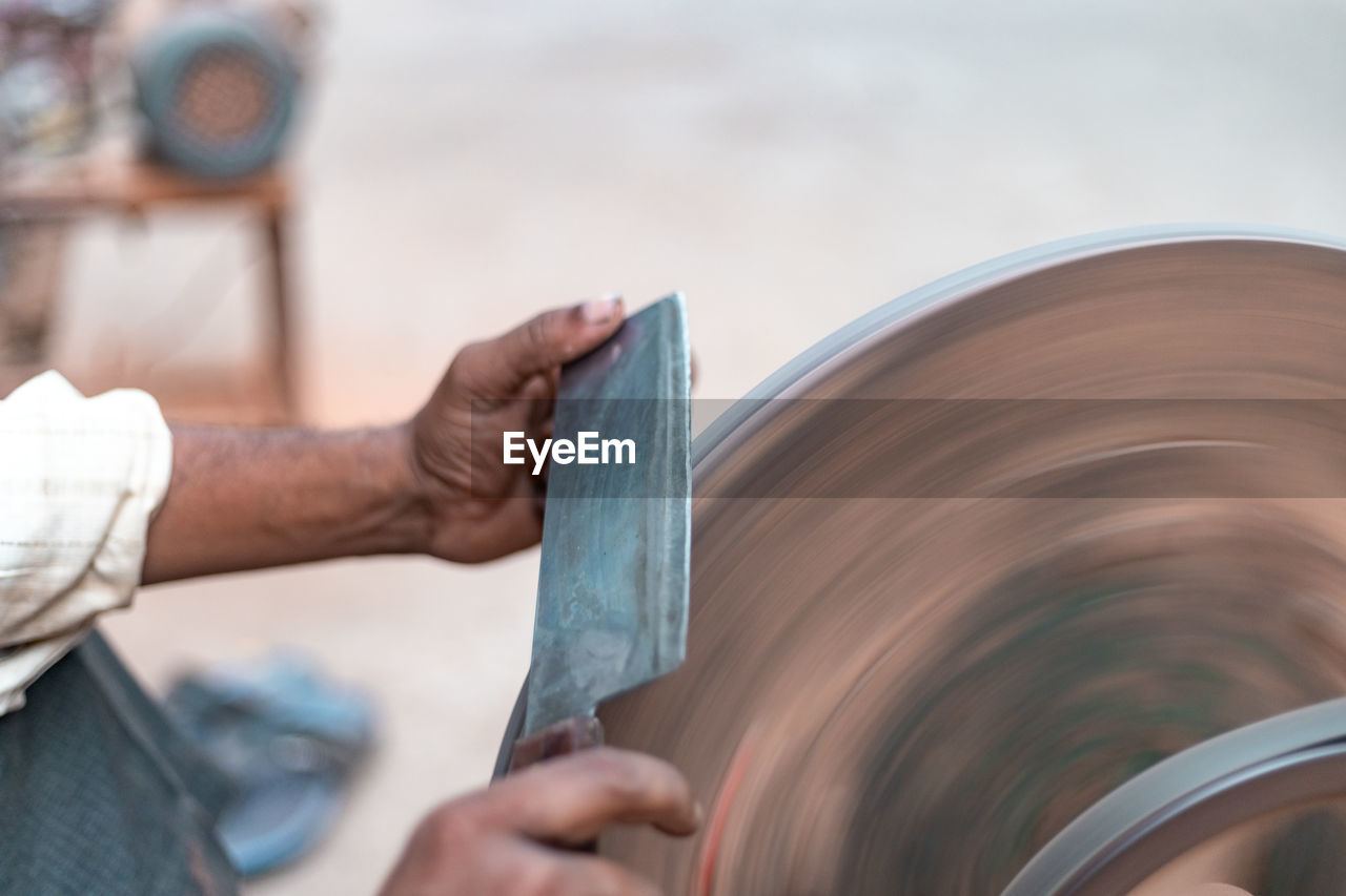 Cropped image of man sharpening knife