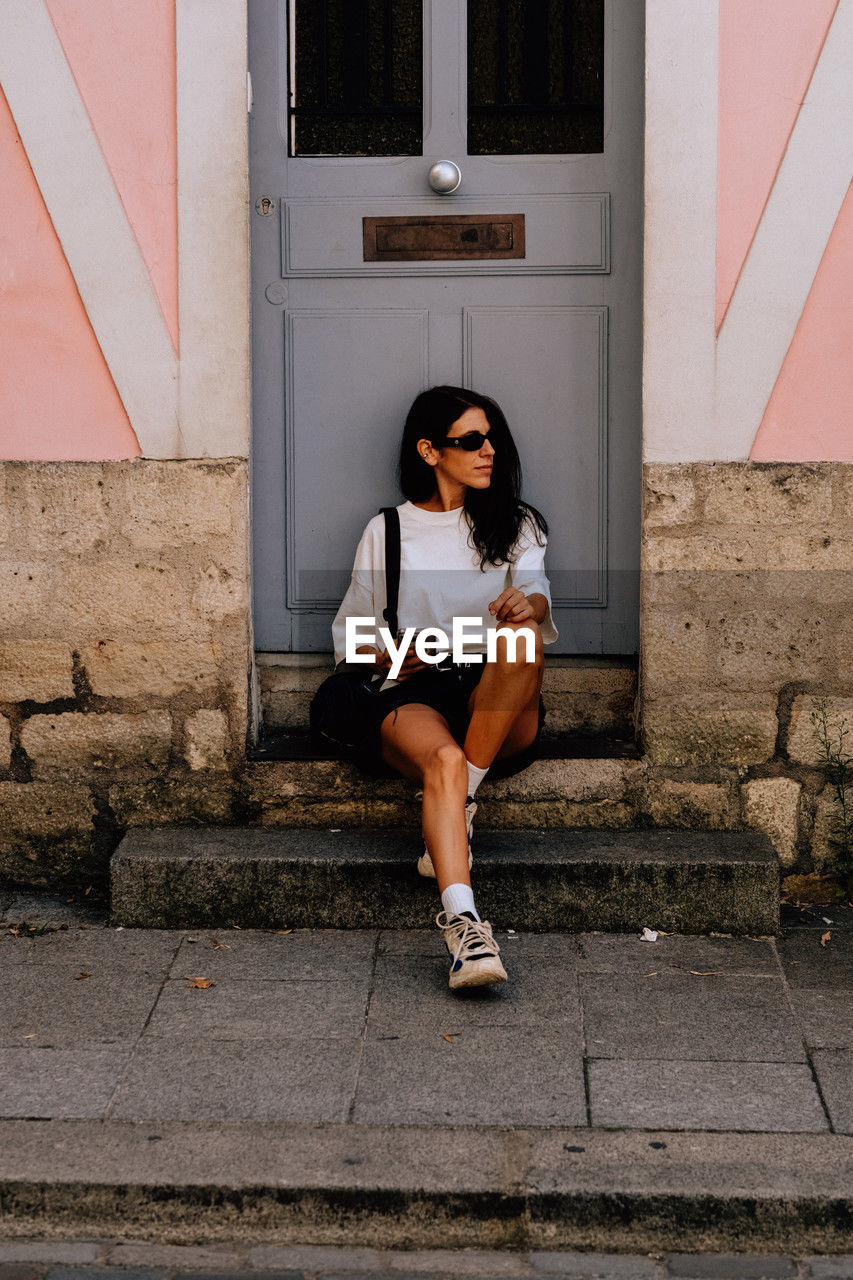 Full length of woman sitting on staircase