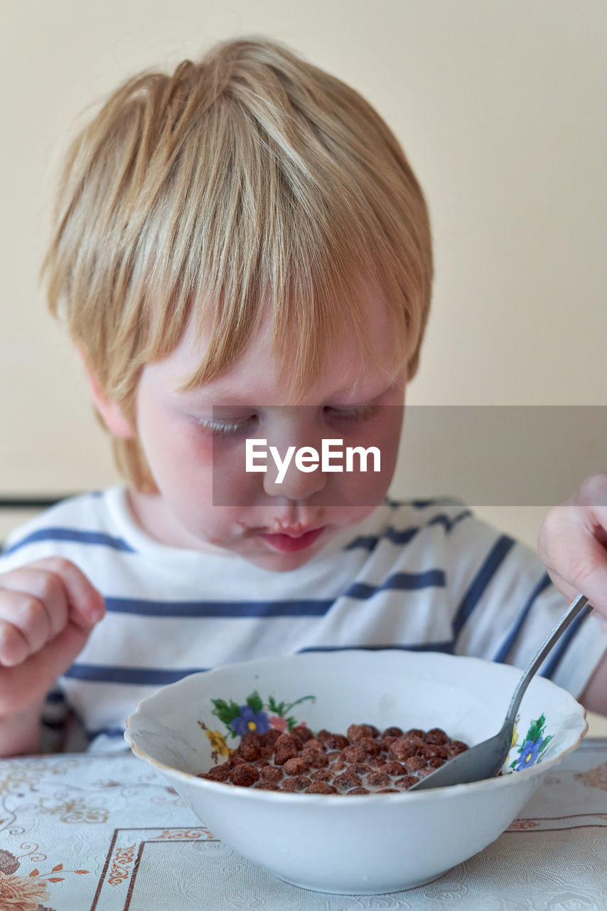 close-up of cute girl eating food at home