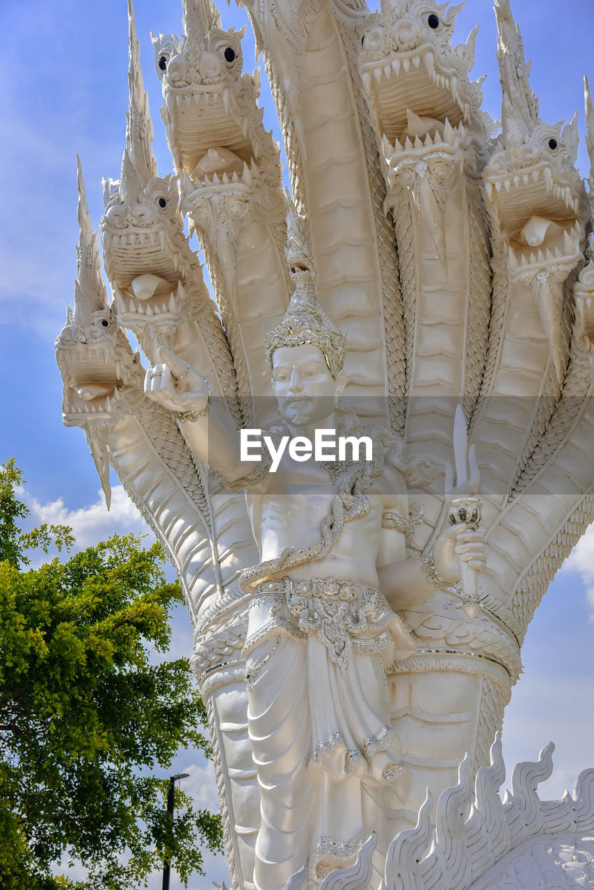 LOW ANGLE VIEW OF STATUE AGAINST TEMPLE