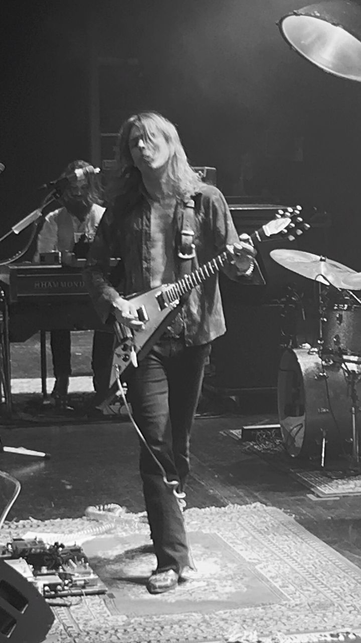 FULL LENGTH PORTRAIT OF YOUNG WOMAN PLAYING MUSIC AT CONCERT