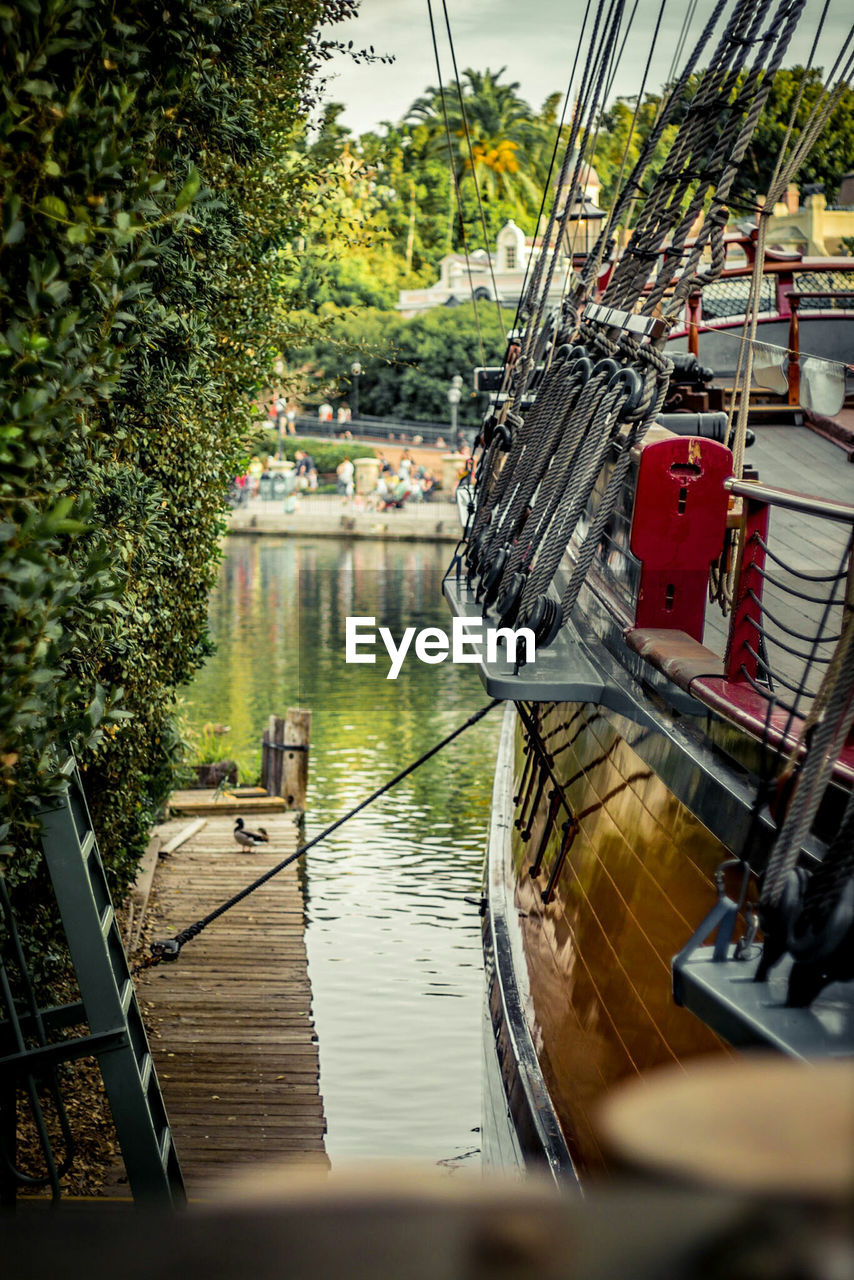 Cropped image of boat moored at pier over lake