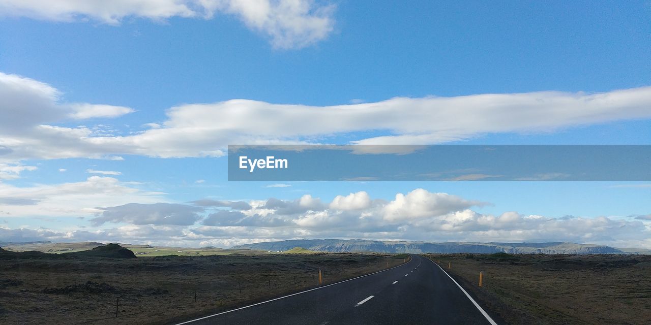 Road by landscape against sky