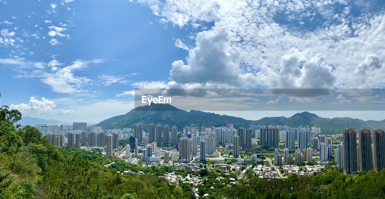 Panoramic view of buildings against cloudy sky