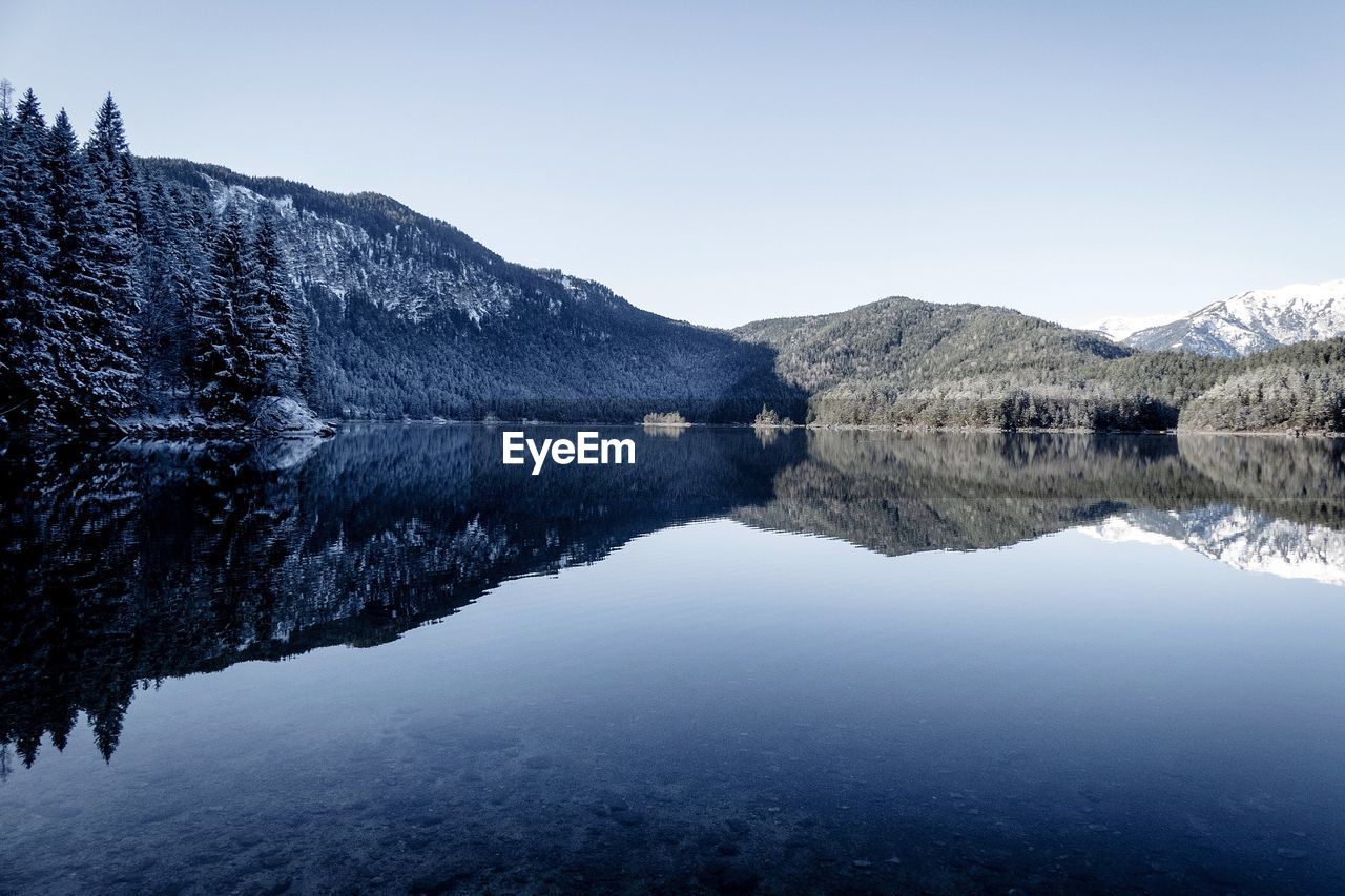 Scenic view of lake and mountains against clear sky