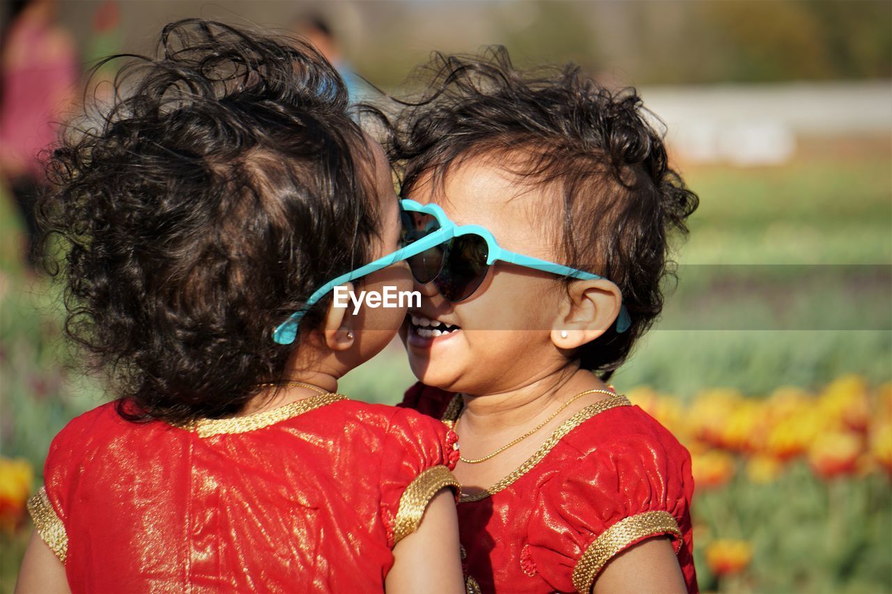 Portrait of happy sisters during sunny day