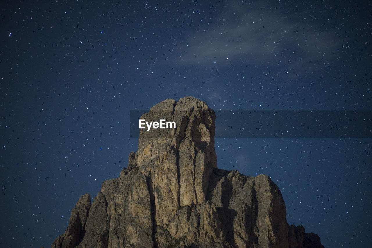 Low angle view of rock formations against sky at night